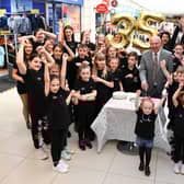 Alex Totten does the honour by cutting the Howgate's 35th birthday cake with help from Project Theatre youngsters.