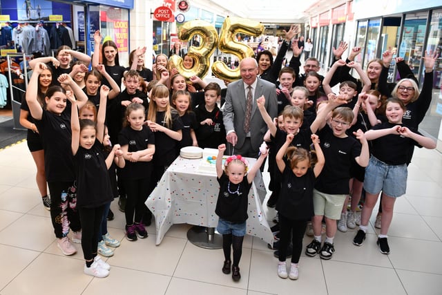 Alex Totten does the honour by cutting the Howgate's 35th birthday cake with help from Project Theatre youngsters.