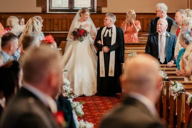 The Reverend Bill Thomson walks daughter Elise Thomson down the aisle to marry Thomas Peden