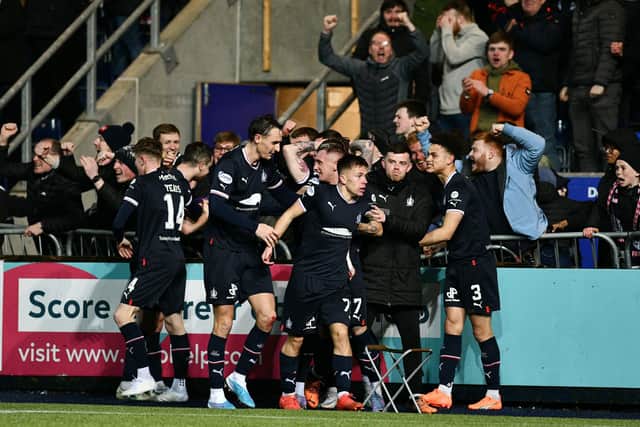 Kai Kennedy is mobbed by his Falkirk team-mates after scoring the winner
