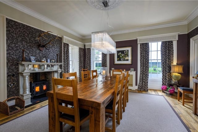 Dining Room with built-in bookshelves and cupboard, central fireplace with solid fuel stove and ornate pillared wooden mantel with inset mirrors.