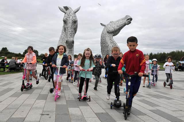 Stenhousemuir girl Mila Sneddon (blue polka dot jacket and pink scooter) was joined by her school friends and family for her Scoot in September event. Picture: Michael Gillen.