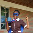 Upile with the daily mug of vitamin-enriched porridge that she receives from Mary’s Meals.