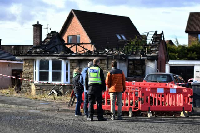 Police remain at the scene of Sunday night's fatal fire