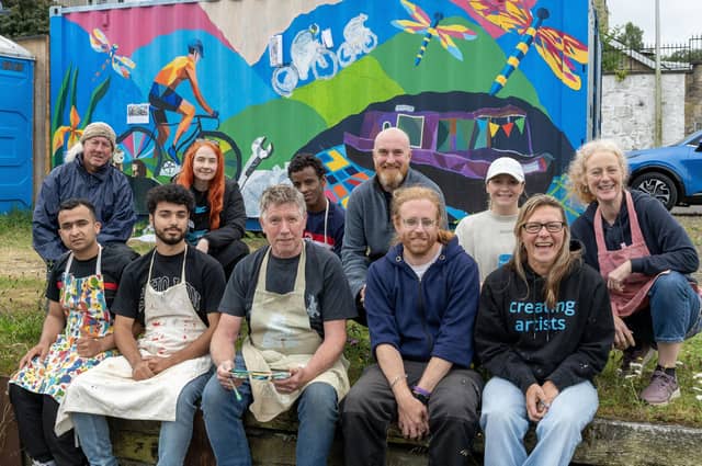 Members of D2 Creative, Go Forth and Clyde and volunteers take a break from mural painting.