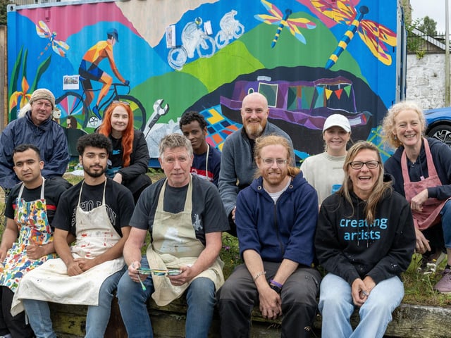 Members of D2 Creative, Go Forth and Clyde and volunteers take a break from mural painting.