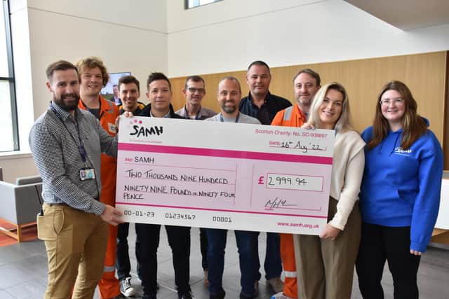 The Ineos C Shift cycle team hand over the money they raised to the Scottish Association for Mental Health (SAMH)