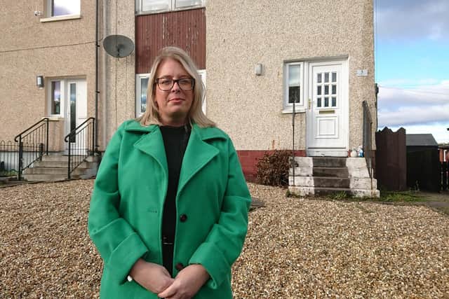 Councillor Claire Mackie Brown outside a house in Limerigg where the tenant has been hit with a £12,000 bill from Scottish Power. Picture:Contributed