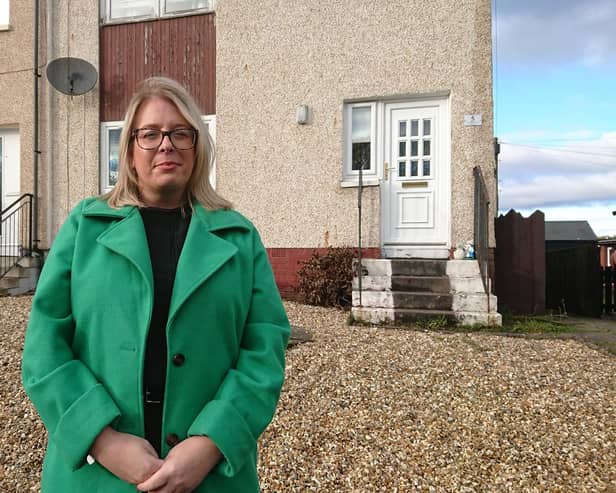 Councillor Claire Mackie Brown outside a house in Limerigg where the tenant has been hit with a £12,000 bill from Scottish Power. Picture:Contributed