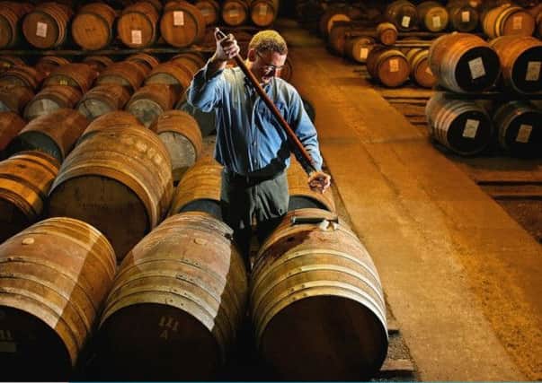 A worker at Bruichladdich distillery takes a whisky sample from a cask. Picture: Getty Images