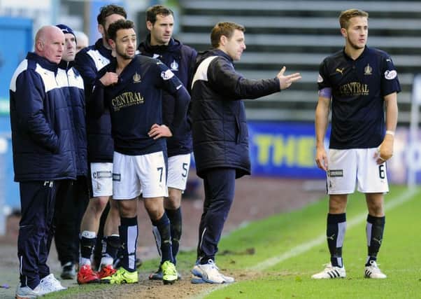 Falkirk players and staff look on as Conor McGrandles is treated on the park. Picture Michael Gillen.