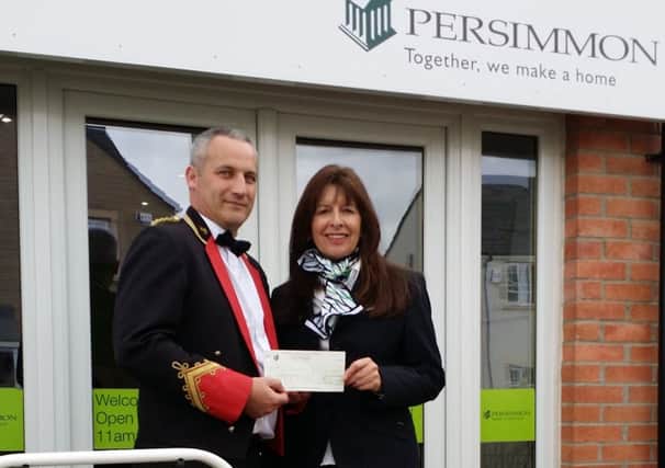 Persimmon Homes sales agent Helen Wigfield hands over cheque to Paul Mckay of Bo'ness and Carriden Band