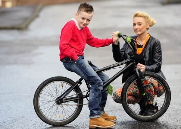 Logan Young with his bike and his mum Emma