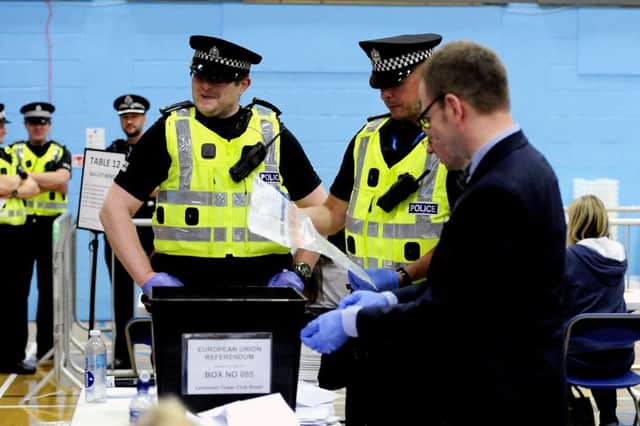 Police watch as one of the ballot boxes is opened
Picture: Michael Gillen
