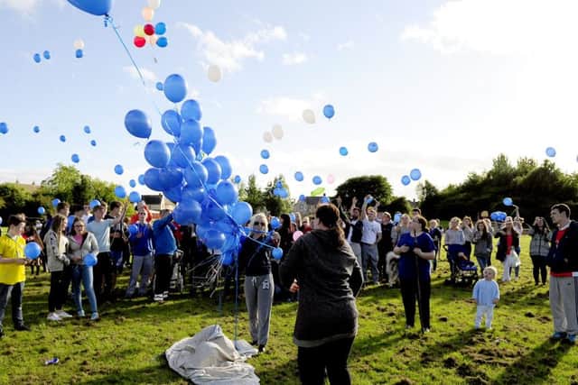 Family and friends release balloons to remember Russell Robertson