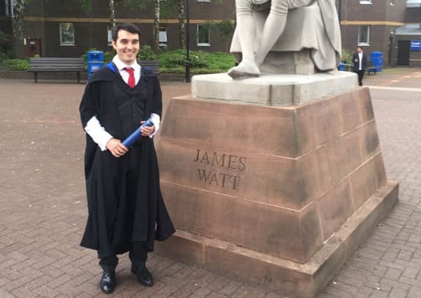Stephen celebrates at the statue of James Watt on his graduation day  from Heriot Watt University