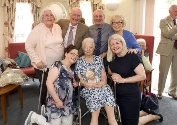 Anne Cummings with her family and card from the Queen. Picture: Craig Halkett