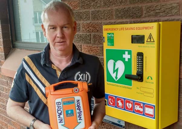 Campaigner Norrie Brown at the newly-installed defibrillator at Maddiston police station