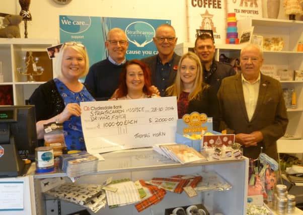 Tom, pictured second left, with fellow fundraisers and staff from the Bonnybridge Strathcarron charity shop