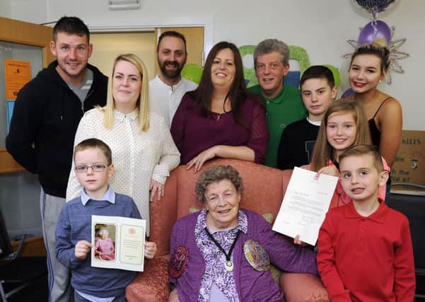 Jean surrounded by her loving family with the card and letter from the Queen. Picture: Michael Gillen