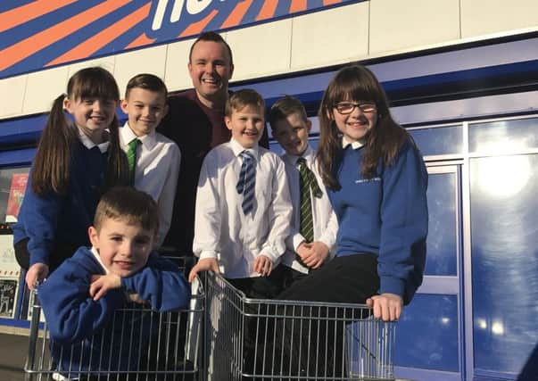 The kids from Denny helped load trolleys full of gifts alongside radio presenter Mark Martin