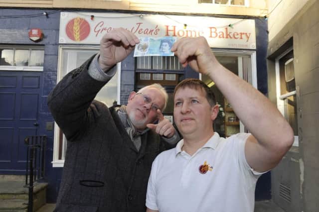 Tony Huggins-Haig and Alan Malone (owner of the bakery) outside Granny Jean's Bakery in Kelso looking out for one of the signed five pound notes.
