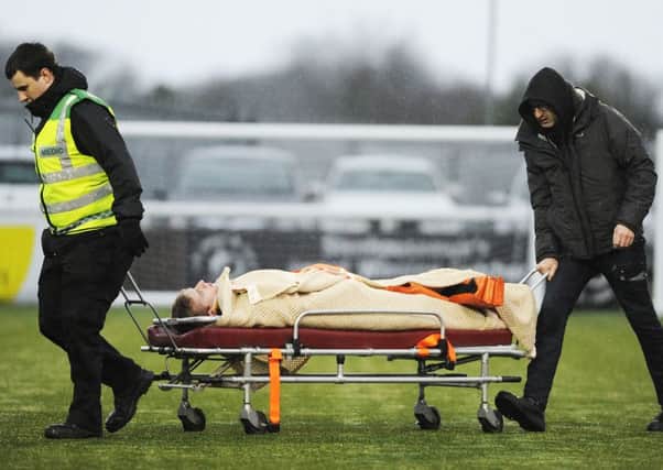 Alistair Roy is wheeled off on a stretcher after his sickening collision which over-shadowed Saturday's match. Pic by Alan Murray