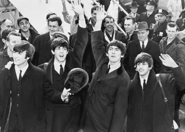 The Beatles wave to fans after arriving at Kennedy Airport. 7 February 1964