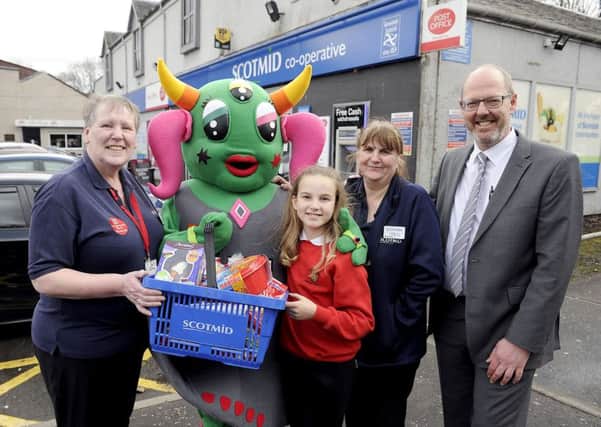 Scotmid's Joanne Taylor presents Jessica Budzynska with some goodies at the unveiling of Baby Bella, Bonnybridge town mascot. Also pictured are Liz Robertson, manager and Robin Thomson, area manager. Picture: Michael Gillen