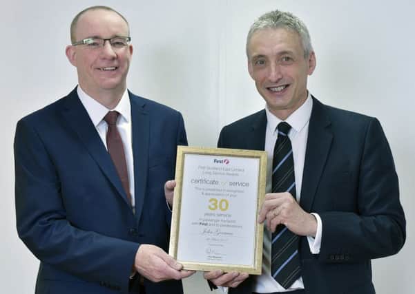 John (left) is congratulated on his 30 years service by Paul McGowan