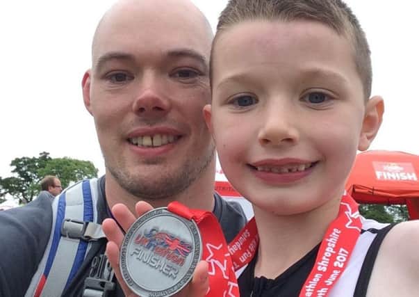 Lewis McAusland (7) celebrates completing a junior triathlon with dad Alastair McAusland
