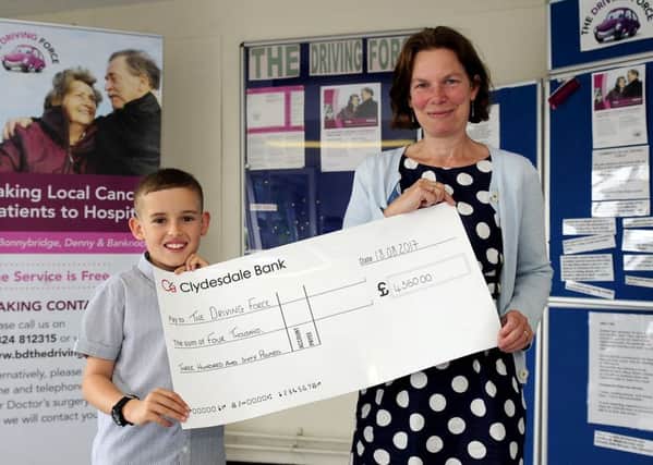 Liam Sherry hands over the cheque for Â£4360 to Dr Bridget McAllister who runs The Driving Force. Picture: Michael Gillen