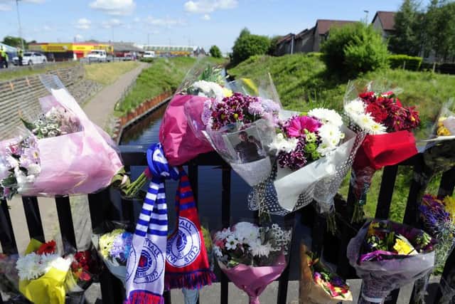 Scores of floral tributes were left at the scene in memory of Russell