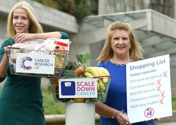 Susan Shaw (from Scottish slimmers) and professor Linda Bauld are pictured firmly crossing items of junk food off a shopping list to back Cancer Research UKs call to the Scottish Government to restrict sales of bargain-buy unhealthy food and drink.
