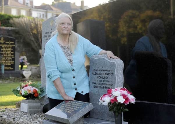 Isabel Nicholson at the graves of her son Scott and husband Alex in Grandsable Cemetery. Picture: Michael Gillen