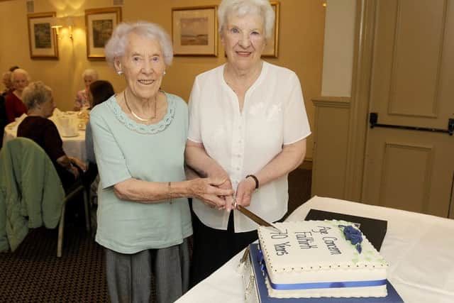 Agnes Philip, left, and chairman Margaret Greenhill cut the cake at the celebration