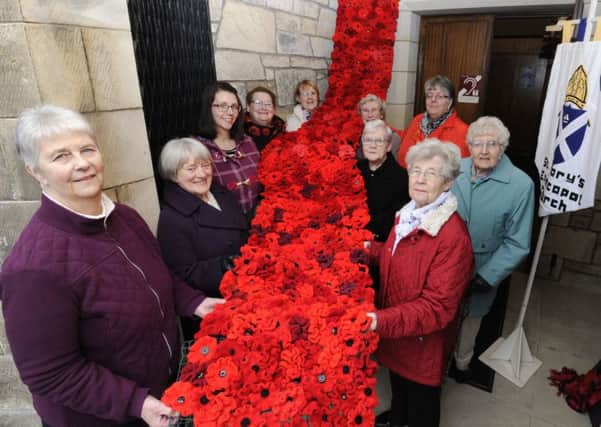 The St Marys Episcopal Church knitters proudly display their poppy watefall