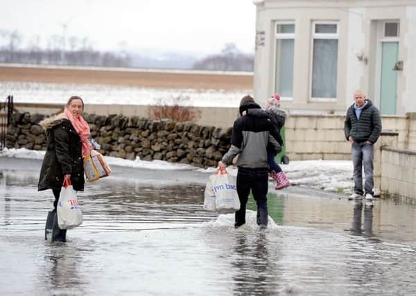 Residents of Letham Terrace wade through flood to their homes.  Pic: Michael Gillen.