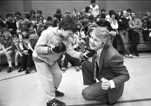 Former world lightweight champion boxer Jim Watt takes one on the chin from a small boy at the opening of Grangemouth's Easter Cavalcade in April 1983.