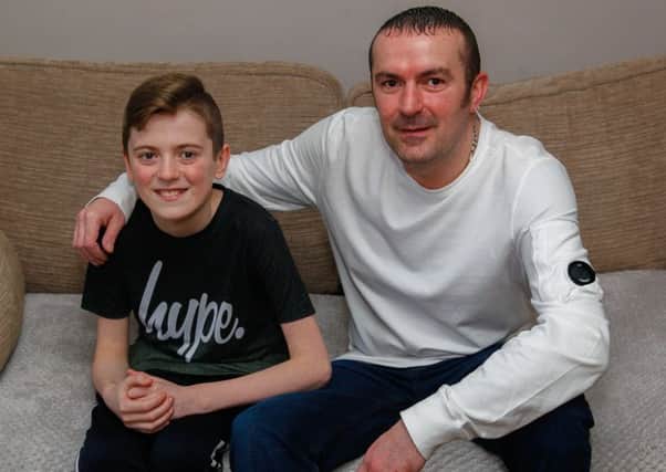 Hero dad Drew Keltie, who rescued a neighbour from her burning flat, with son Aiden (12)