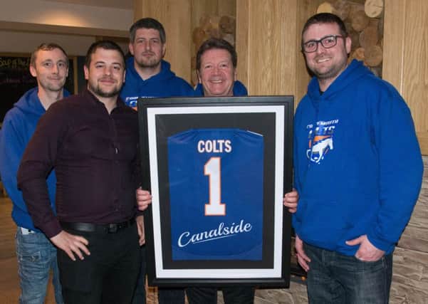 Colts players hand over a framed shirt to Canalsides manager Nick Wales as a thanks for their sponsorship of Grangemouth Flag Football Club.