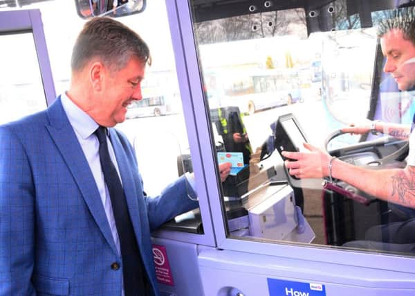 Scottish economy minister Keith Brown uses the new contactless payment technology on a First Bus service