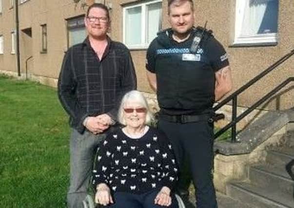 Bainsford resident Janet Conroy in her new wheelchair donated by Gary Riddell, alongside PC Ryan Smith