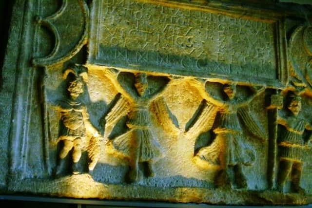 The figures on this stone would once have been painted in colour - the letters would have been in red