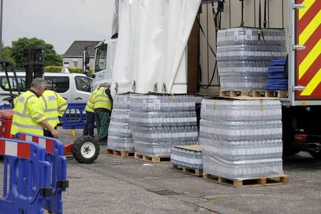Bottled water was distributed to residents affected by a burst pipe in James Croft Drive. Picture by Michael Gillen