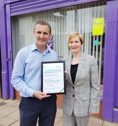 Michael Matheson MSP is presented with his Carer Positive award by Fiona Collie, policy & public affairs manager at Carers Scotland