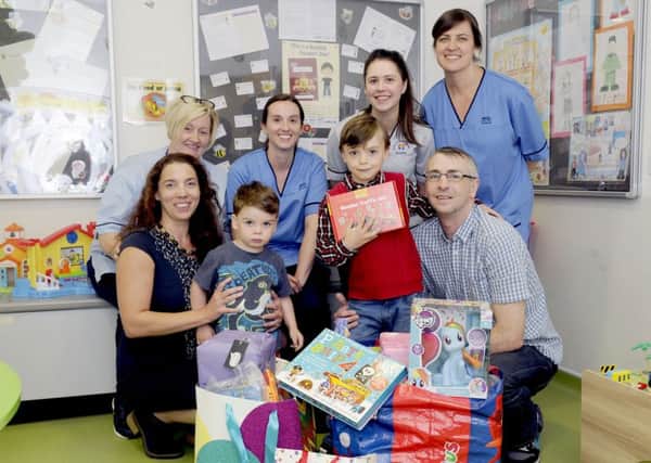 Maddiston boy Ciaran Krykant (front centre) donated dozens of birthday gifts to the Forth Valley Royal Hospital Children's Ward. Ciaran is pictured with (front) dad Peter, mum Catherine and brother Conrad and (back row) Liz Cook, nursing auxiliary, and nurses Laura Connelly, Laura McDowall and Claire Finlay. Picture by Michael Gillen