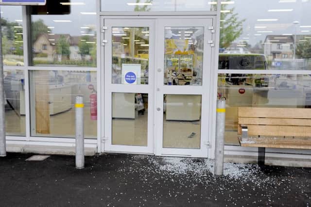 A smashed window at the store in Glasgow Road following the overnight incidents. Picture Michael Gillen