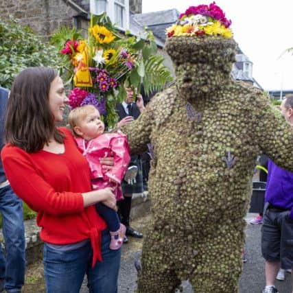One-year-old Edith McQuatt and her mum Laura meet the Burryman. Pic: SWNS