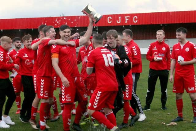 Camelon celebrate with their trophy after the match, held by club captain Don Morrison (Pics: Dan Rous)